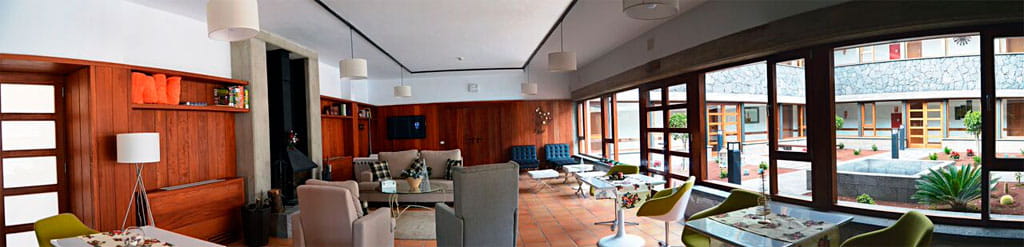 Sala de estar luminosa con ventanas amplias y decoración moderna en Tenerife.