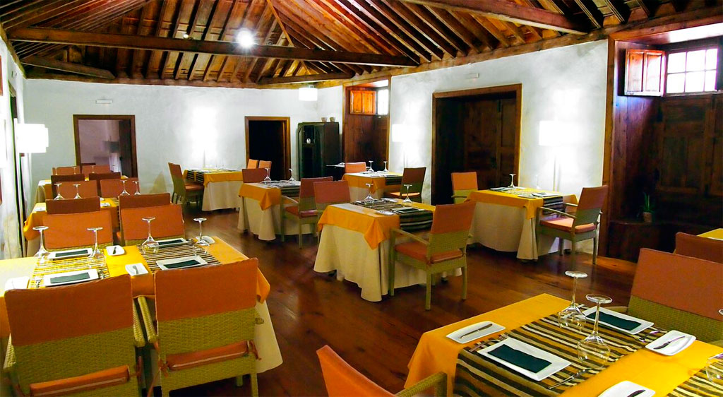 Comedor con mesas preparadas para comensales en un restaurante de Tenerife.