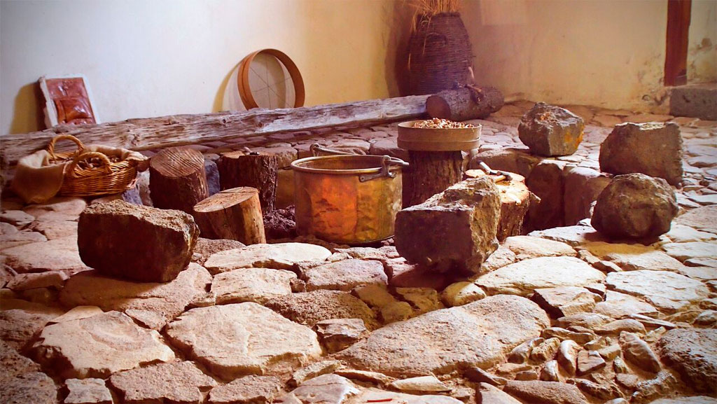 Cocina tradicional en Tenerife con suelo de piedra y utensilios antiguos.