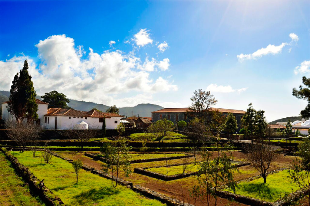 Jardines y casas tradicionales cerca de La Orotava, Tenerife, bajo un cielo despejado.