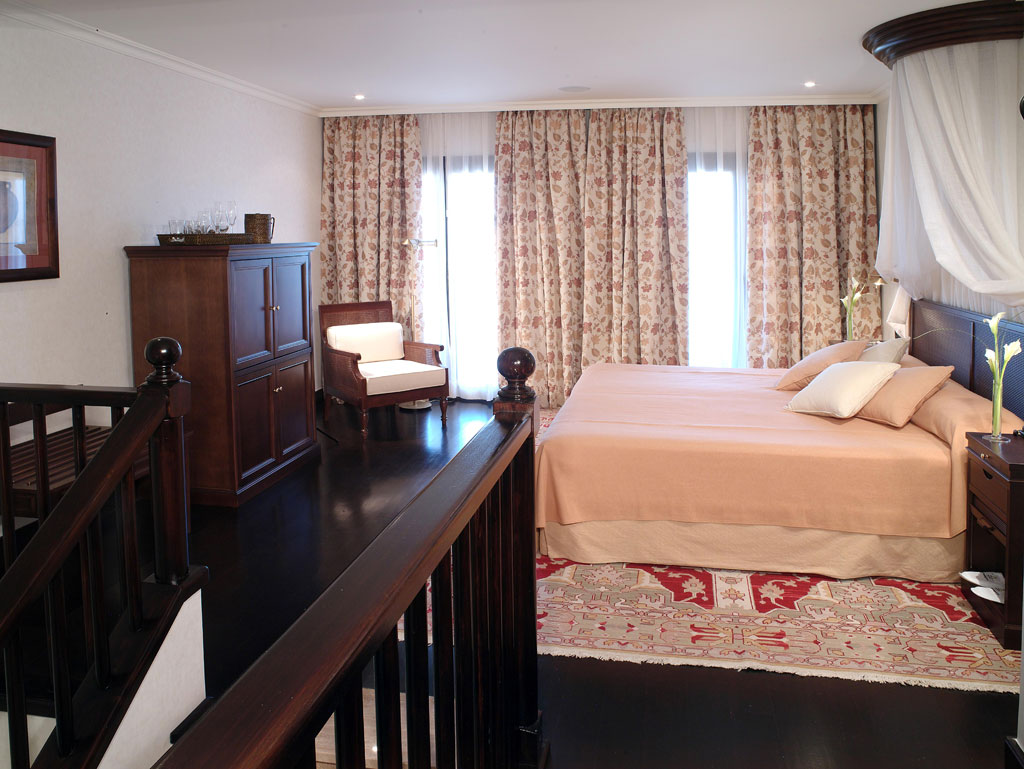 Habitación con cama grande, armario de madera y alfombra en Tenerife.