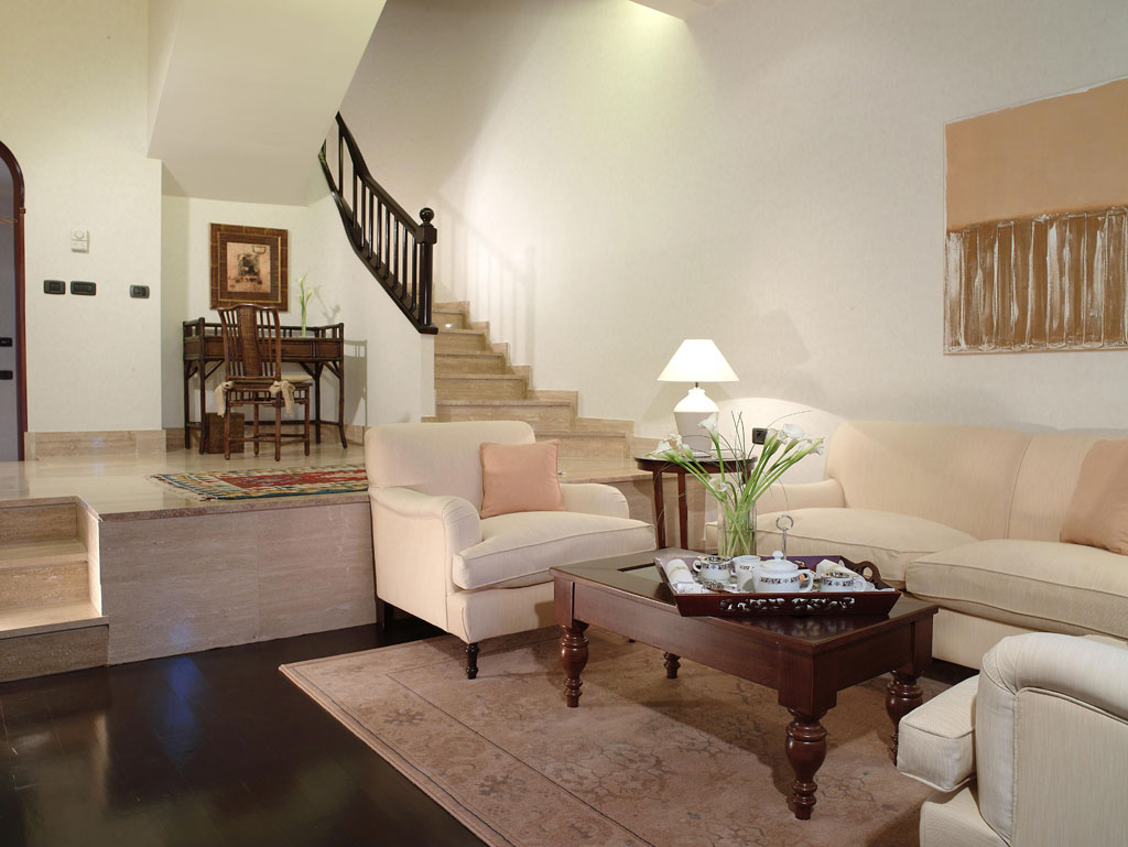 Sala de estar con sofá, mesa de centro, escaleras y escritorio en una casa de Tenerife.