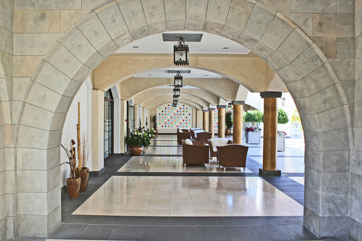 Arcadas de piedra con muebles y plantas en un pasillo de Tenerife.