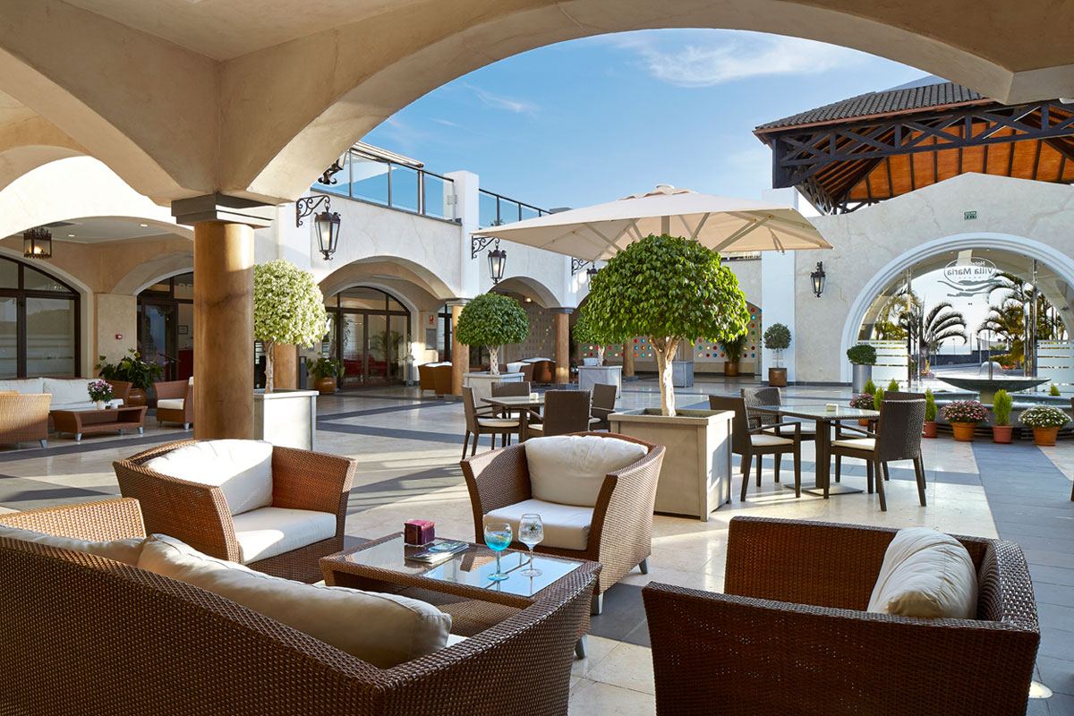 Terraza con muebles de mimbre y sombrillas, Hotel en Tenerife.