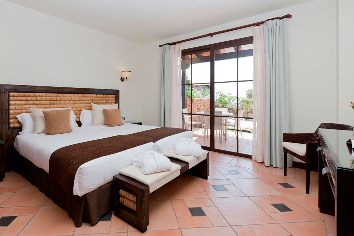 Habitación con cama grande, ventanales y terraza en hotel de Tenerife.