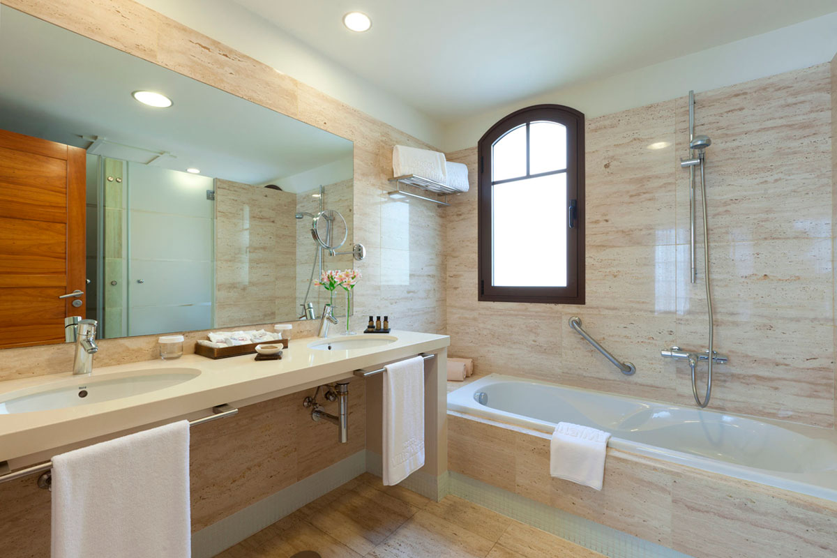 Baño moderno con lavabo doble y bañera en hotel de Tenerife.