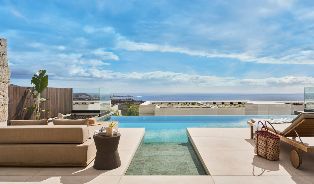 Terraza con piscina y vistas al mar en Tenerife, día soleado.