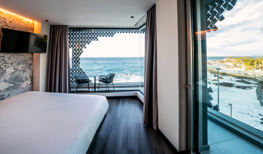 Habitación con vista al mar en Tenerife, mostrando mesa y sillas en balcón.