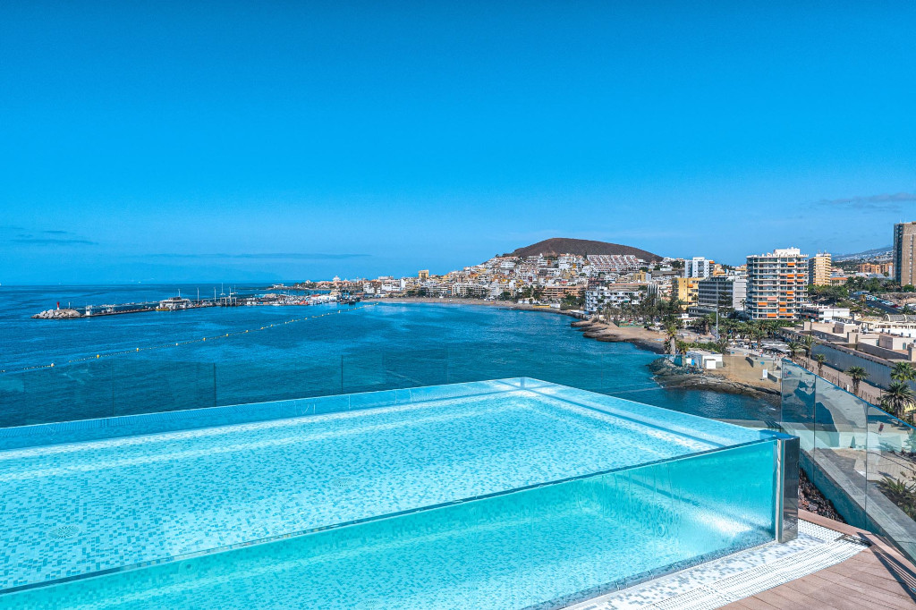 Piscina infinita con vista al mar y la costa de Los Cristianos, Tenerife.