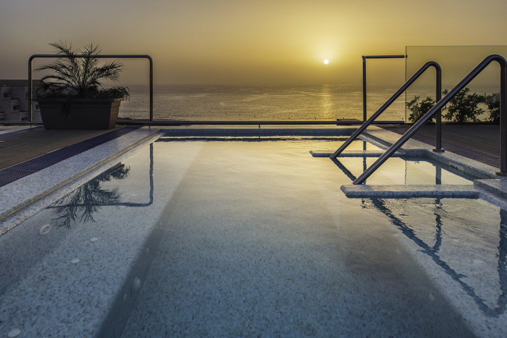 Piscina en la azotea al atardecer con vista al mar en Tenerife.