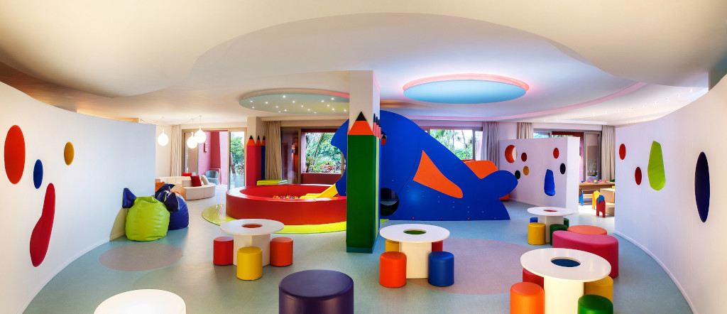 Sala de juegos colorida para niños en un hotel de Tenerife con mesas y cojines.