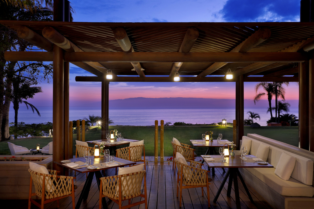 Restaurante al aire libre con vista al océano al atardecer en Tenerife.