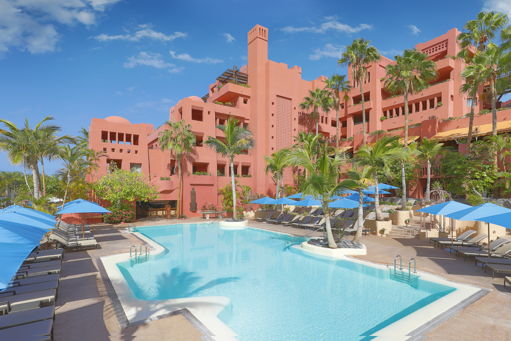 Piscina rodeada de tumbonas y sombrillas en un resort en Tenerife.
