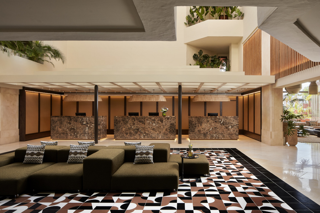 Recepción moderna y luminosa con sofás y mostradores decorativos en hotel de Tenerife.