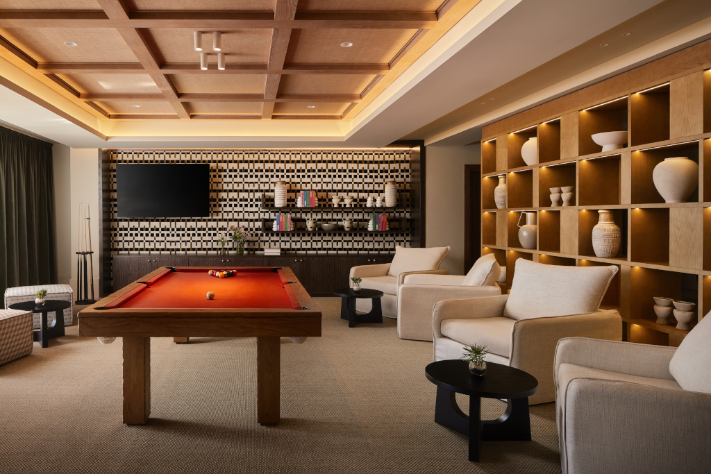 Sala de estar con mesa de billar, televisor, sofás y estanterías decorativas en Tenerife.