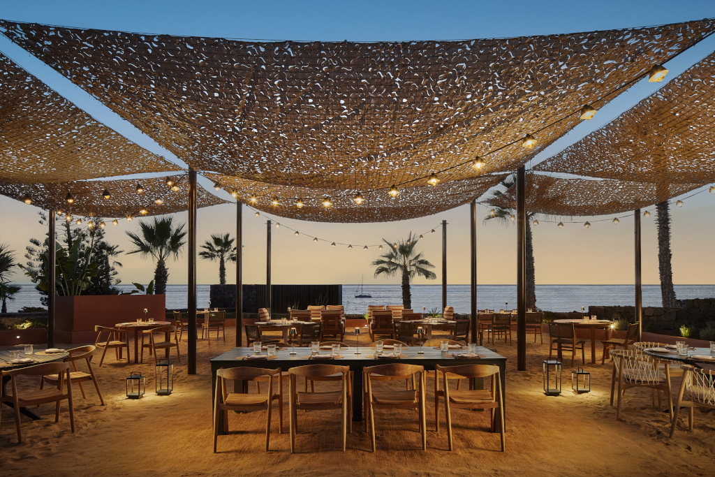 Restaurante al aire libre en Tenerife con vistas al mar al atardecer.