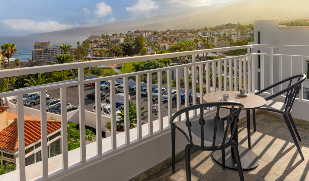 Terraza con mesa y sillas, vista al mar y ciudad en Puerto de la Cruz, Tenerife.