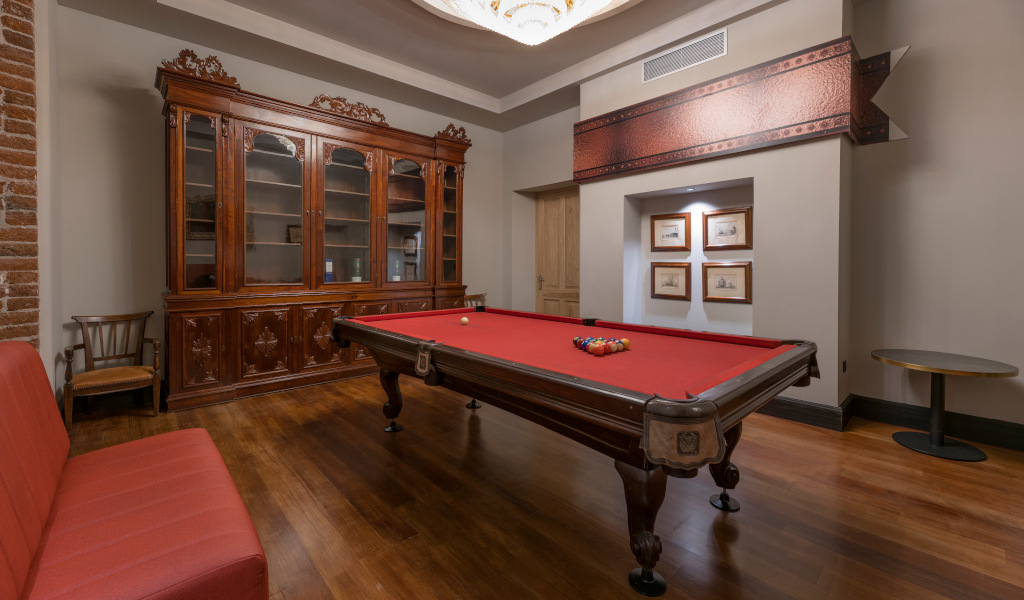 Mesa de billar roja con bolas, armario de madera al fondo en Tenerife.
