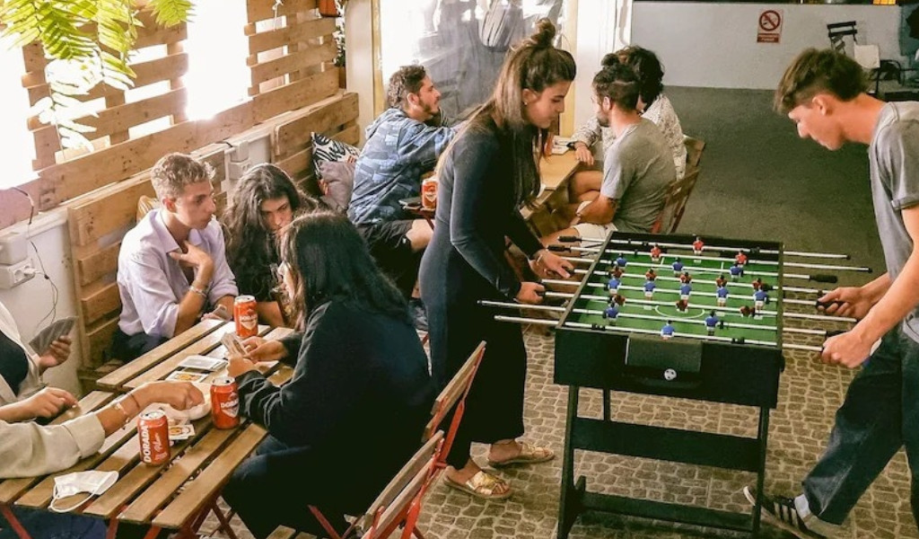 Personas jugando al futbolín y cartas en un café en Tenerife.