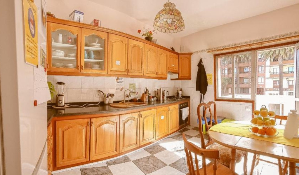 Cocina con muebles de madera y ventana grande en Tenerife.