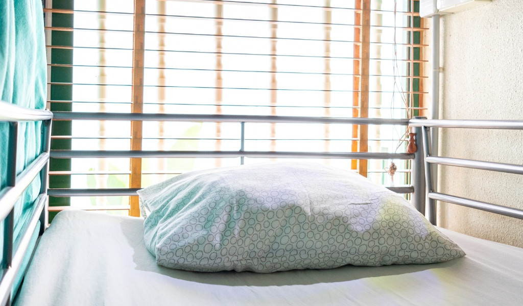 Cama con almohada en habitación iluminada en Tenerife.