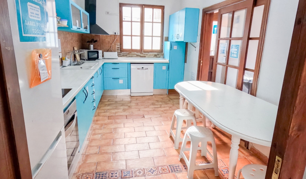 Cocina azul y blanca con mesa y taburetes en casa de La Laguna, Tenerife.