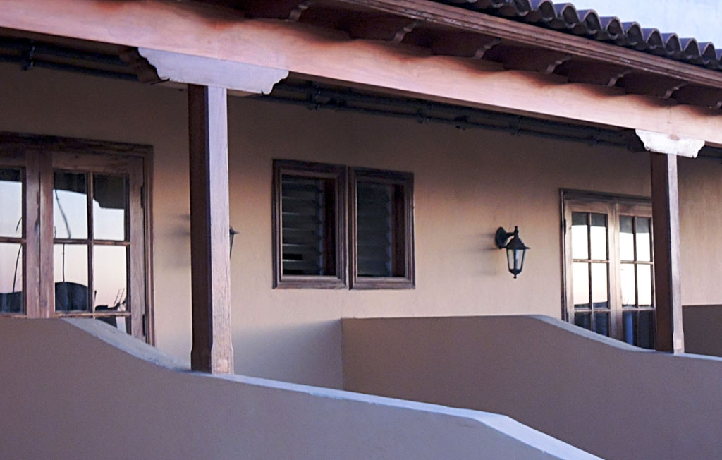 Ventanas de madera y lámpara en una fachada en Tenerife.