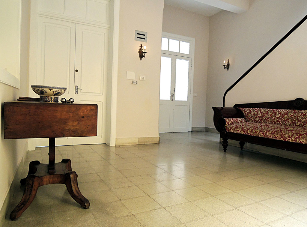 Sala de estar con sofá, mesa de madera y puerta blanca en Tenerife.