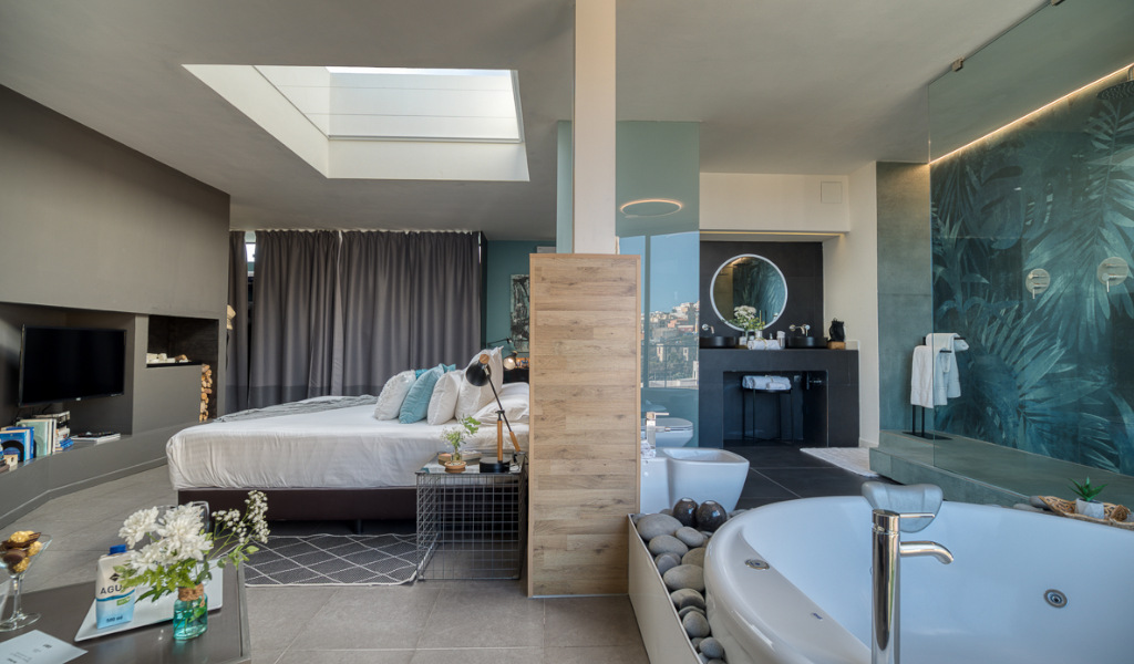 Habitación moderna con jacuzzi, cama, ducha y detalles de decoración en Tenerife.