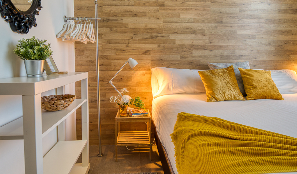 Cama con cojines amarillos en una habitación moderna en Tenerife.