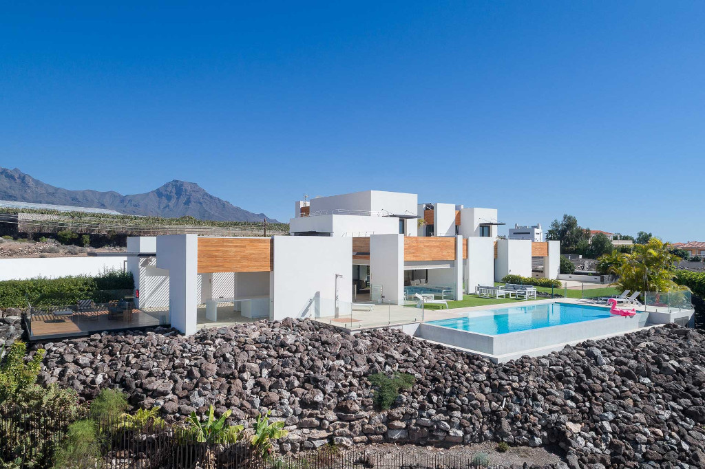 Casa moderna con piscina y montañas al fondo en Tenerife.