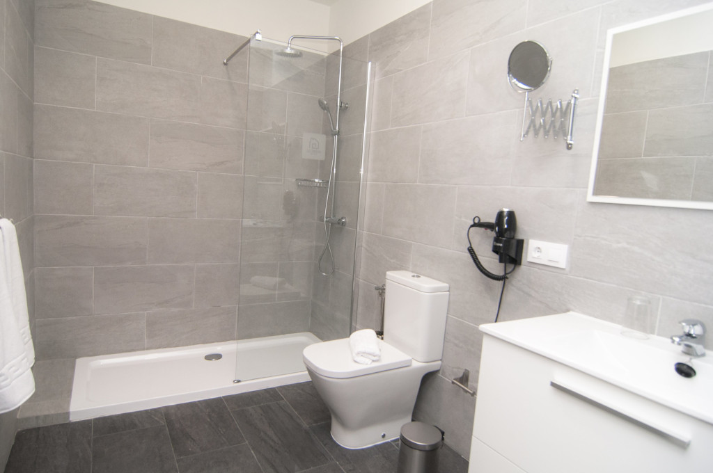 Baño moderno con ducha, inodoro y lavabo en hotel de Tenerife.