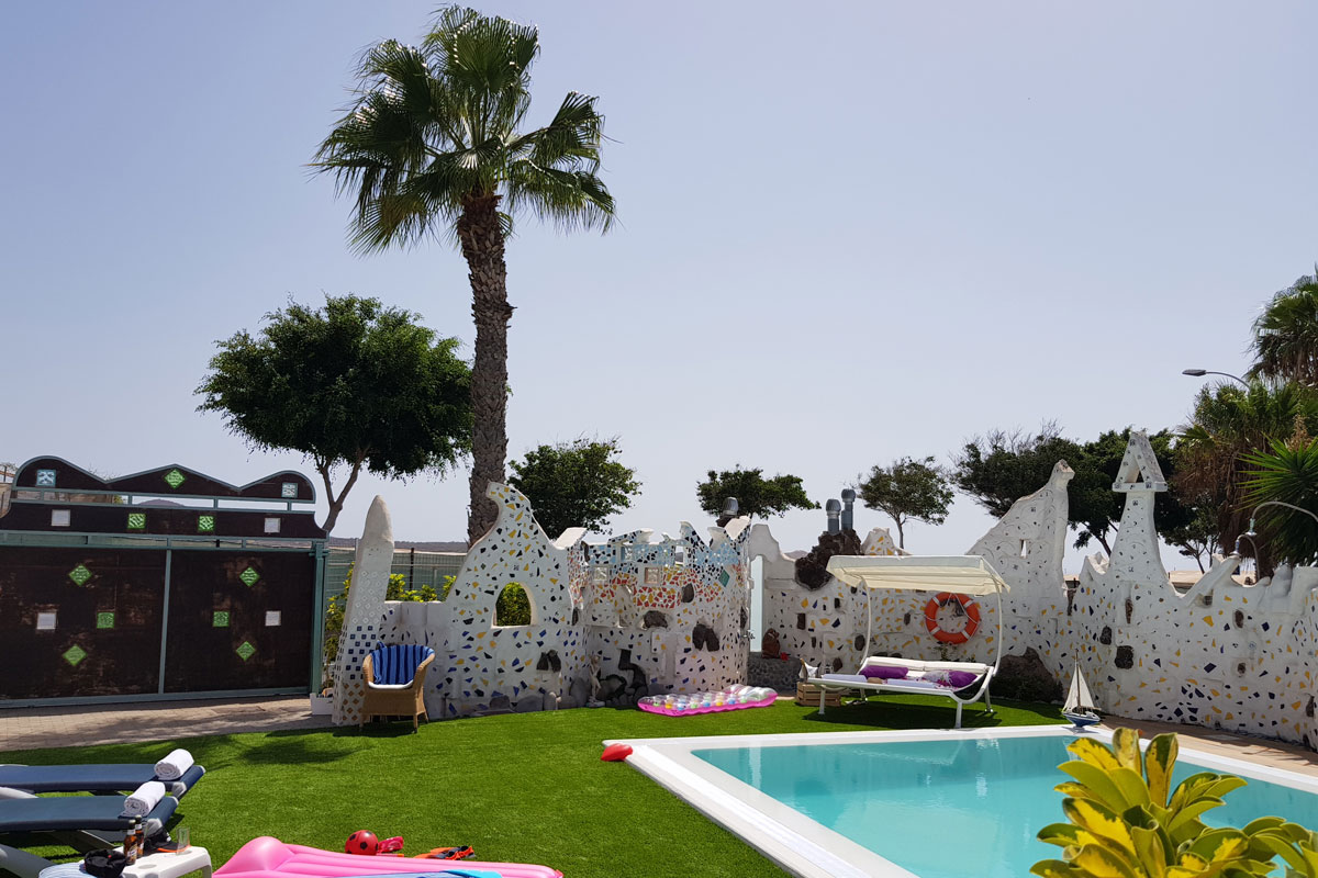 Piscina al aire libre con tumbonas y palmeras en Tenerife.