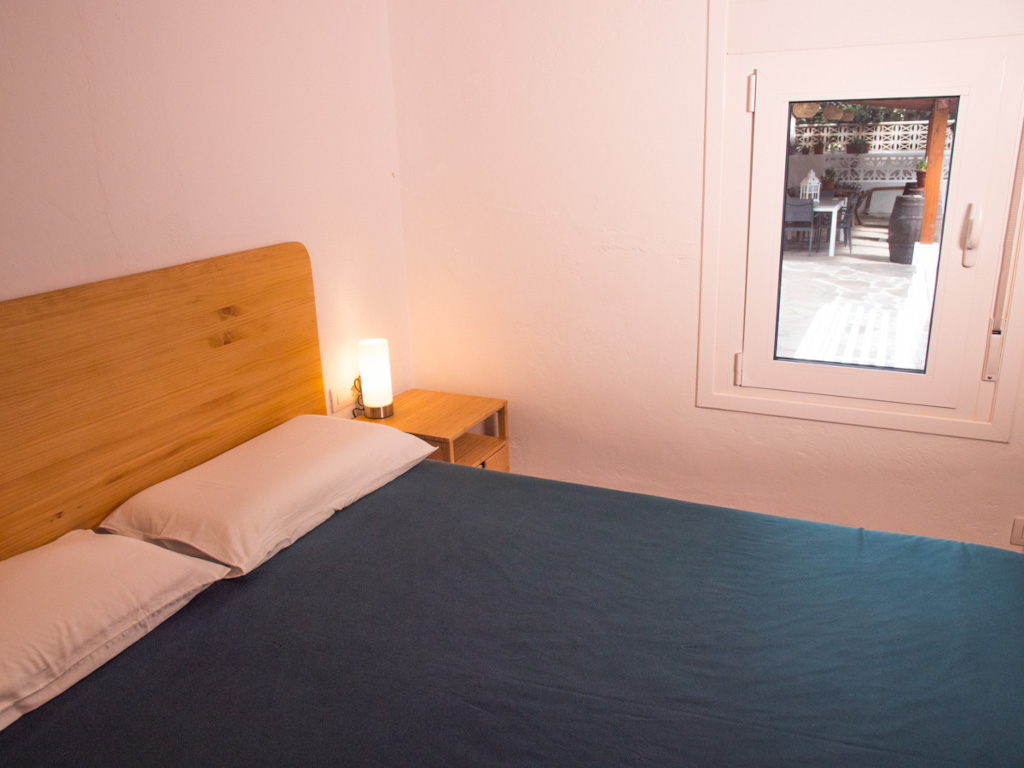 Habitación con cama grande y lámpara junto a ventana en Tenerife.