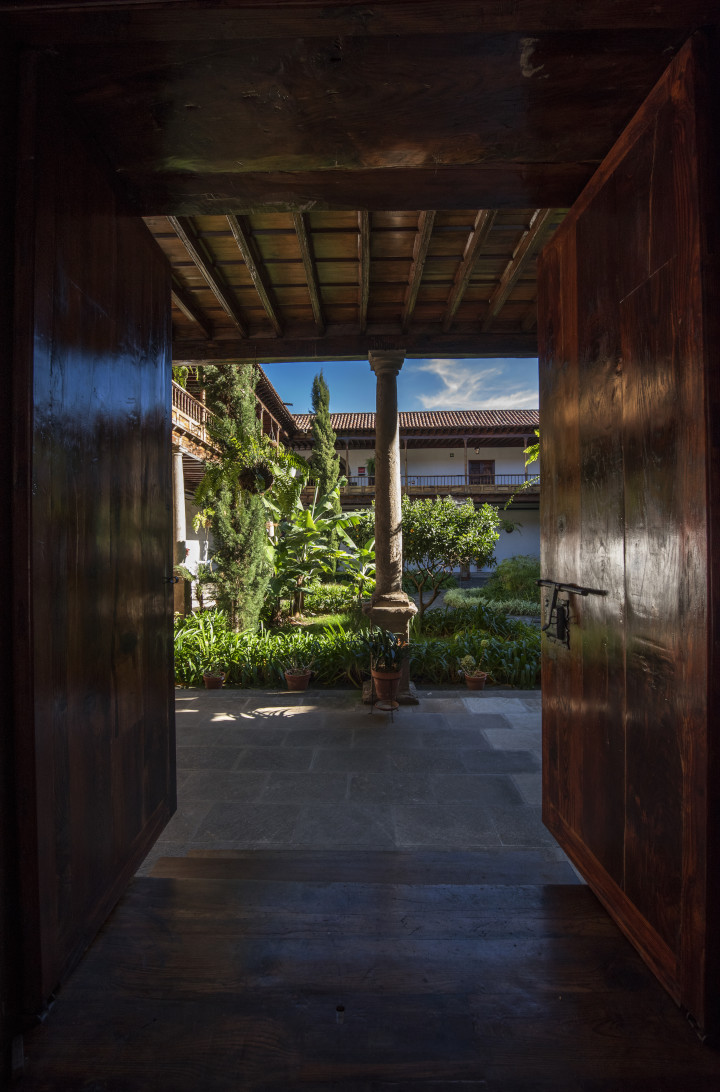 Patio interior con plantas y columnas, visto desde una puerta en La Laguna, Tenerife.