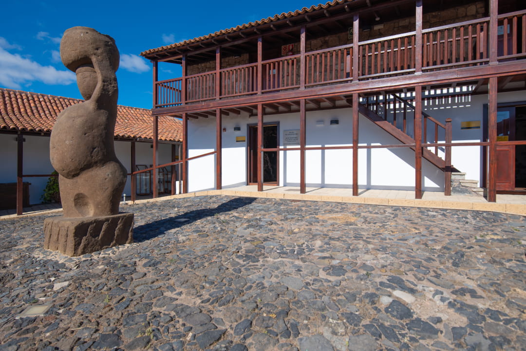 Escultura de piedra y edificio de madera en Vilaflor, Tenerife.
