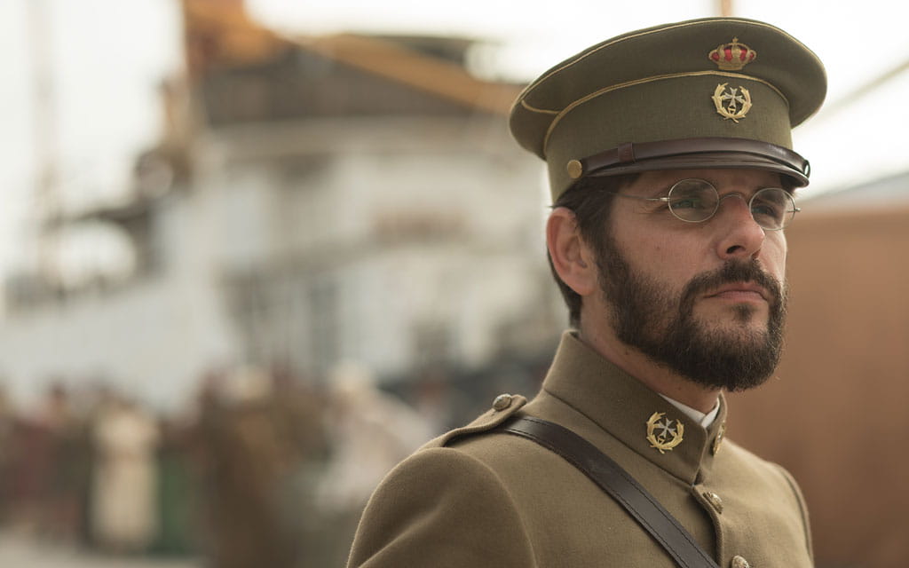 Oficial militar con uniforme de época junto a un barco en Tenerife.