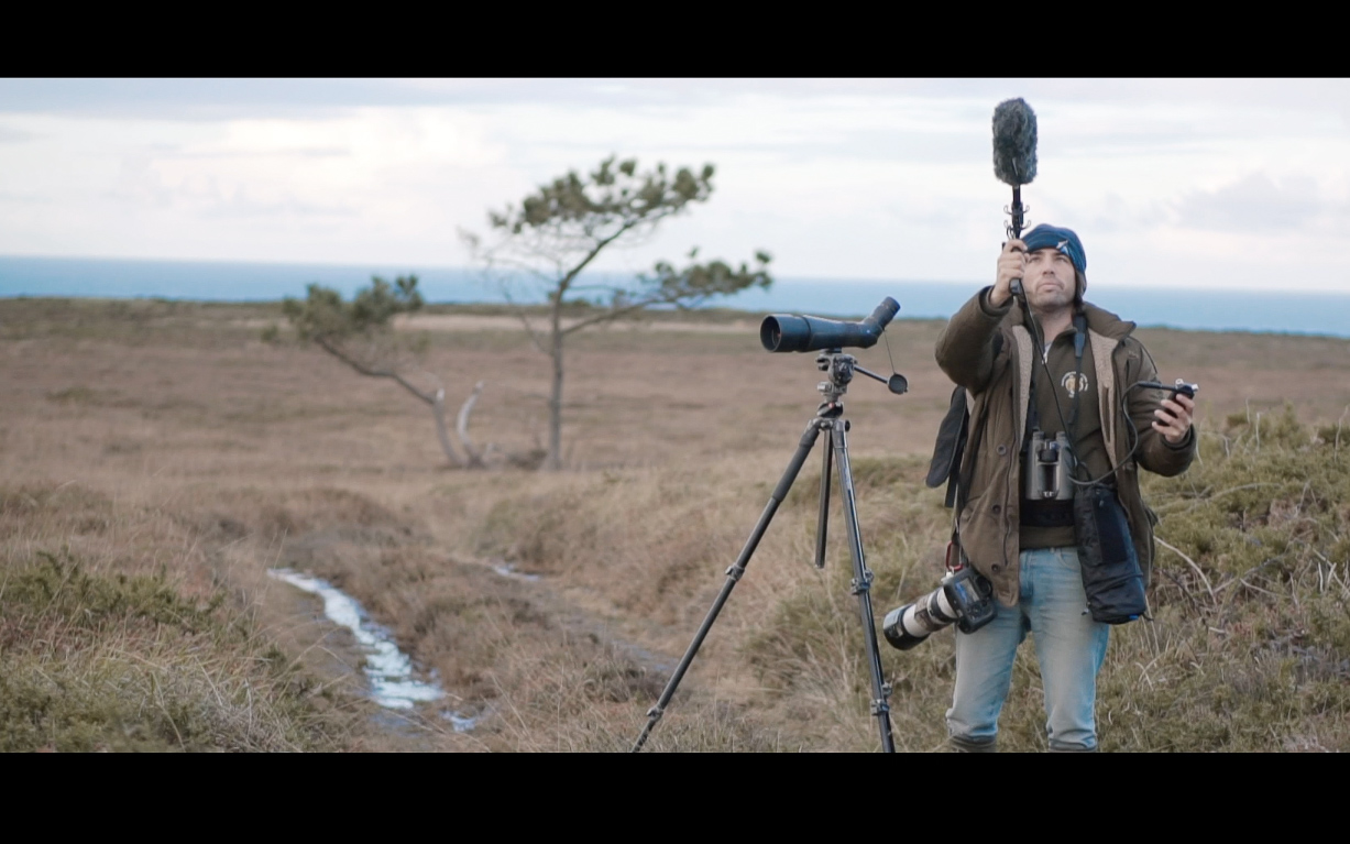 Persona grabando sonido en un campo con vistas al mar en Tenerife.