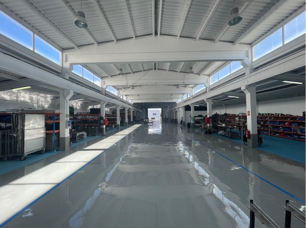 Interior de un almacén industrial con estantes y techo alto en Tenerife.