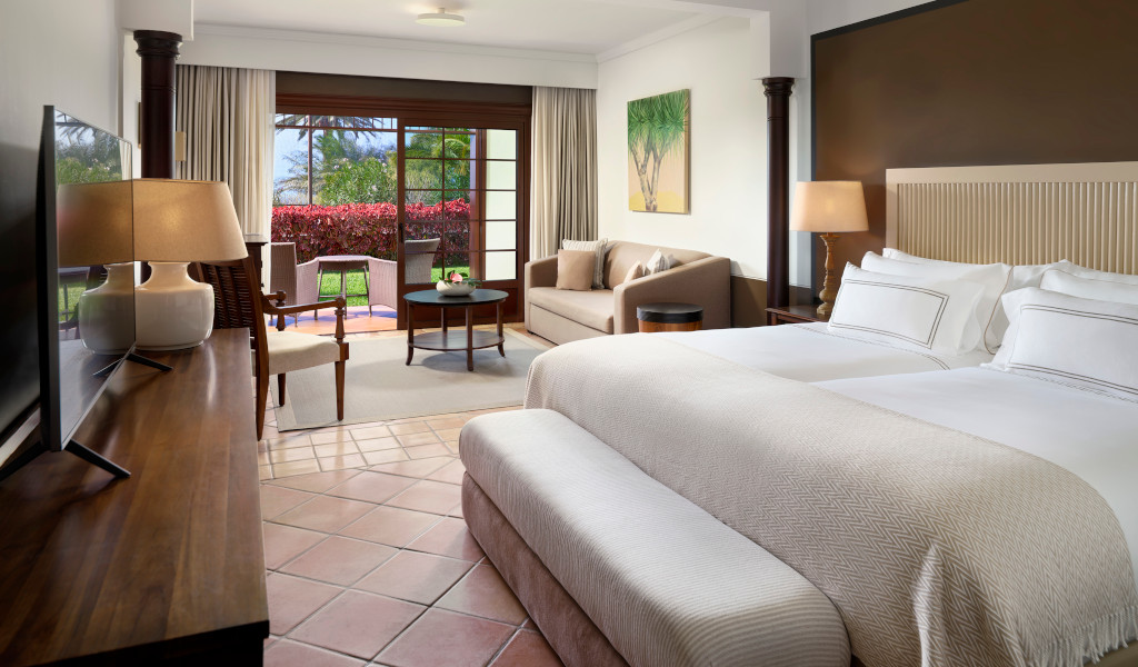 Habitación de hotel en Tenerife con cama grande y vistas al jardín.