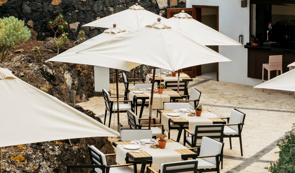 Terraza con mesas y sombrillas en un restaurante al aire libre en Tenerife.