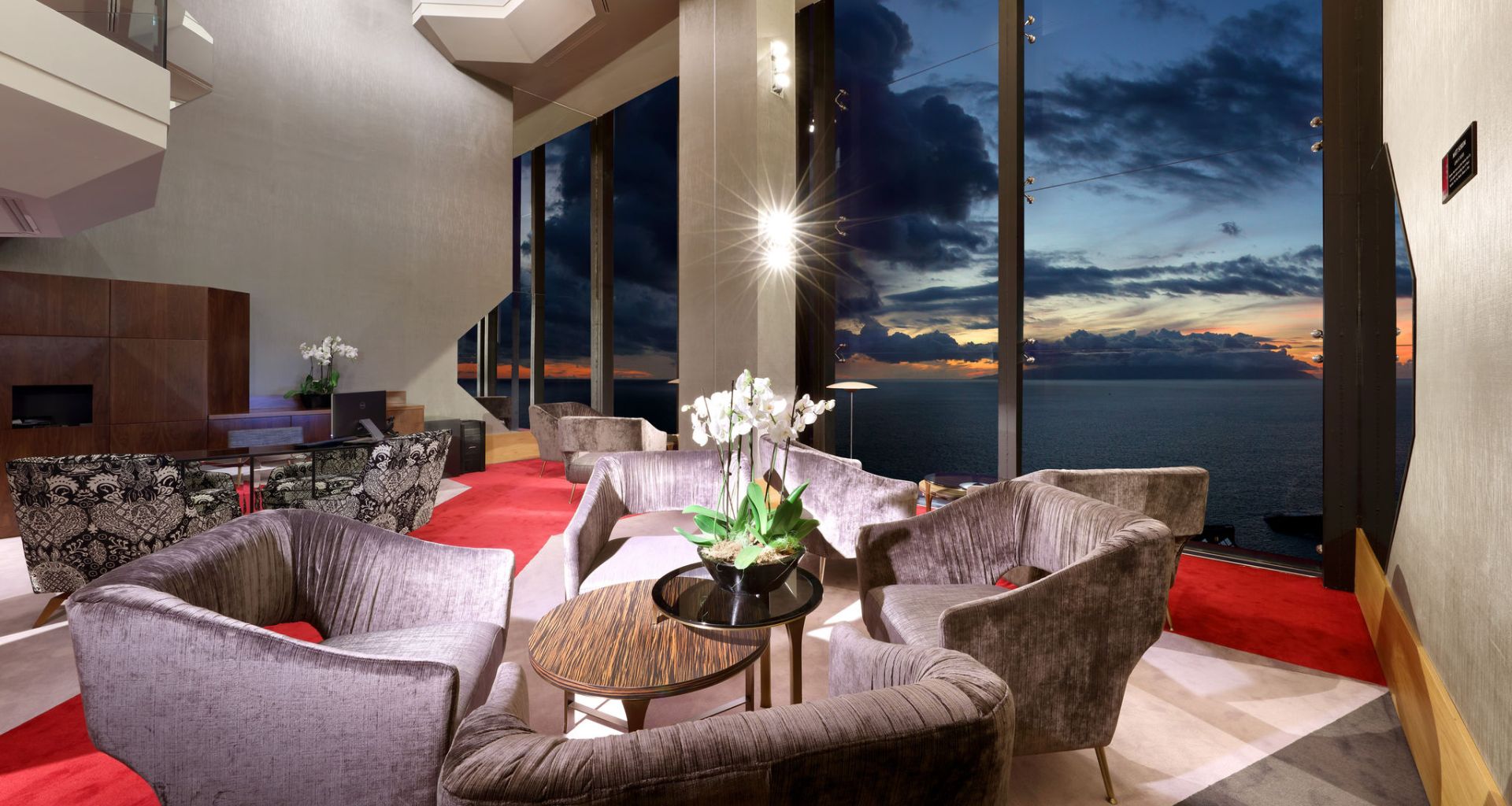 Sala de estar moderna con sillones y vista al mar al atardecer en Tenerife.