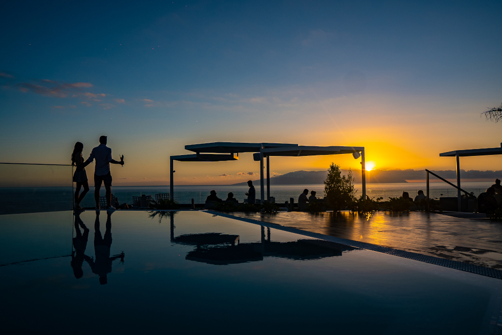Pareja en terraza al atardecer frente al mar en Tenerife.