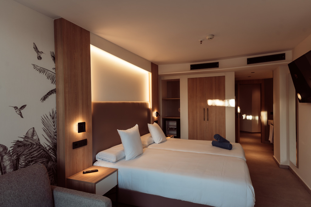 Habitación de hotel en Tenerife con cama doble, iluminación suave y armario empotrado.