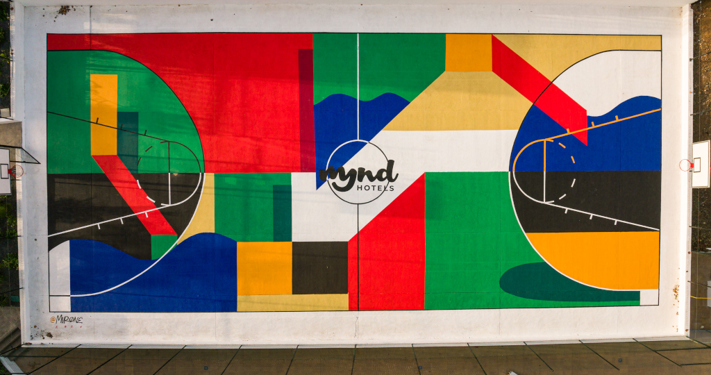 Arte mural colorido con formas geométricas y texto mynd hoteles, en Tenerife.