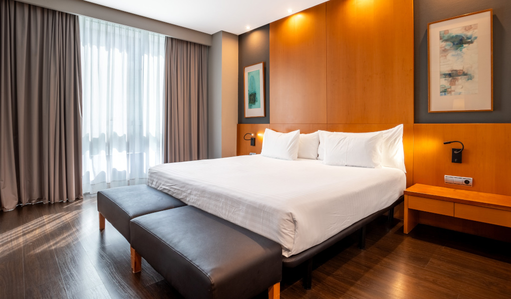 Cama matrimonial con almohadas blancas en una habitación estilo moderno en Tenerife.