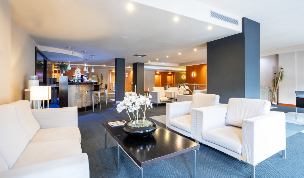 Sala de estar moderna con sofás blancos y una mesa central en un hotel de Tenerife.