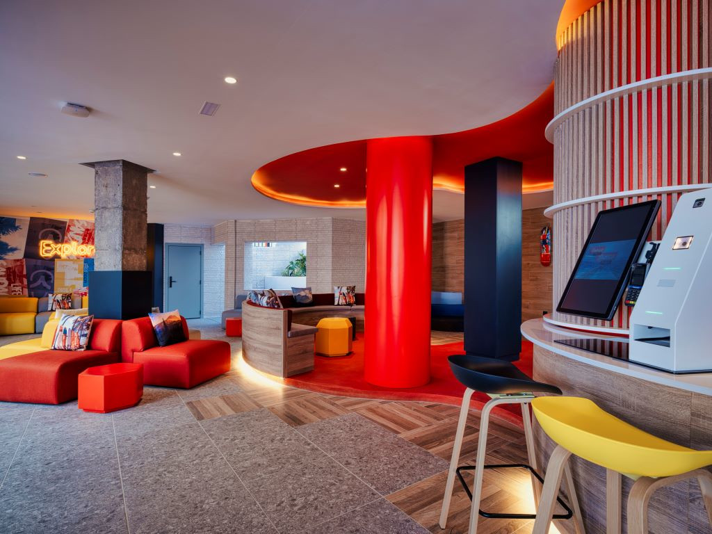 Vestíbulo moderno con sofás rojos y tecnología en Santa Cruz de Tenerife.