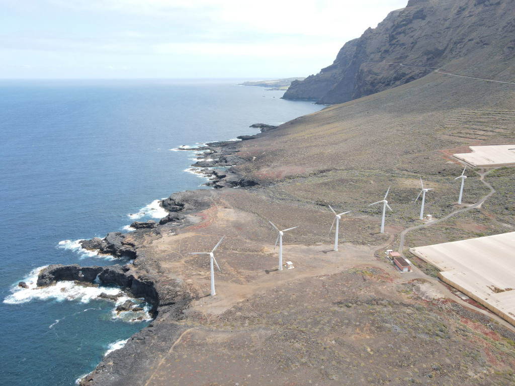 Aerogeneradores en la costa de Tenerife junto a acantilados y mar.