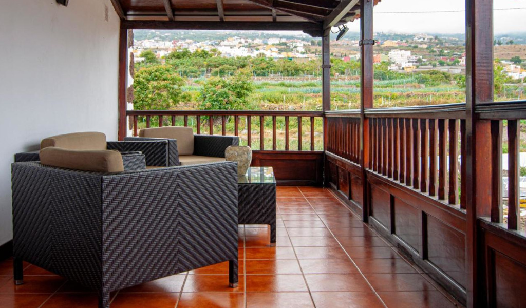 Terraza con muebles de mimbre y vistas al campo en Tenerife.